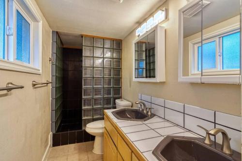 baño con lavabo, aseo y ventanas en PRODUCTIVITY VILLA: Perfect for WFH & occasions en Kirkland