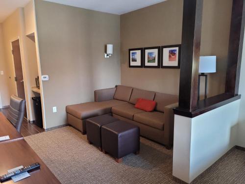 a living room with a brown couch and a red pillow at Comfort Suites Kanab National Park Area in Kanab