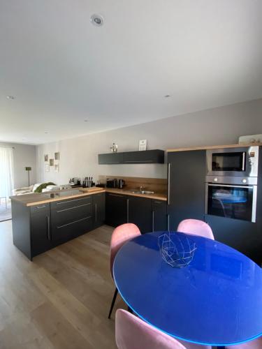 a kitchen with a blue table and pink chairs at Ferienhaus mit Blick ins Grüne in Contwig