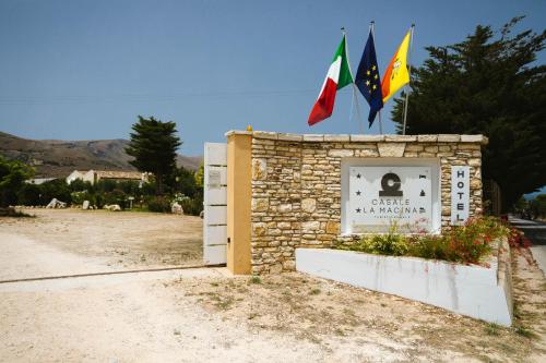 a sign with two flags on top of a building at Casale la Macina Residence Scopello in Scopello