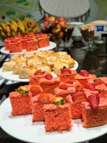 a table topped with plates of food with fruit at Íbis Budget Uberlândia in Uberlândia