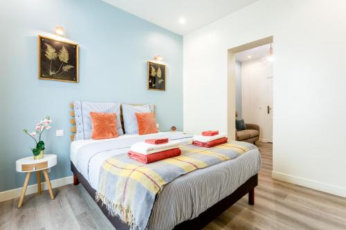 - une chambre avec un lit king-size et des oreillers orange dans l'établissement StayLib - GARIBALDI 2 PIECES PORTE DE MONTMARTRE, à Saint-Ouen