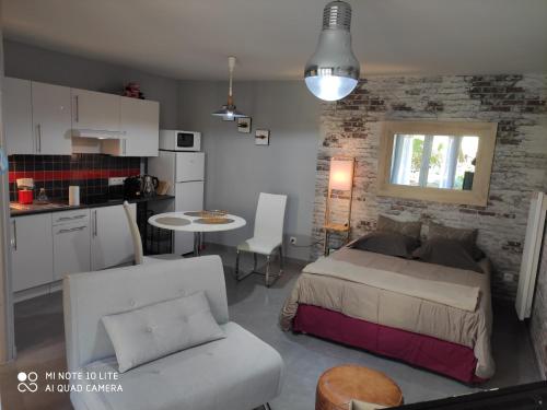 une chambre avec un lit et une table et une cuisine dans l'établissement LA PAUSE studio sur le quai Maupassant à Fécamp, à Fécamp