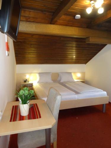 a bedroom with a large bed and a table at Pension Scherwirt in Graz