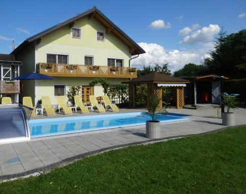 ein Haus mit einem Pool vor einem Haus in der Unterkunft Pension Scherwirt in Graz