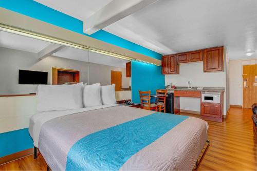 a hotel room with a large bed and a kitchen at Motel 6-Idaho Falls, ID - Snake River in Idaho Falls