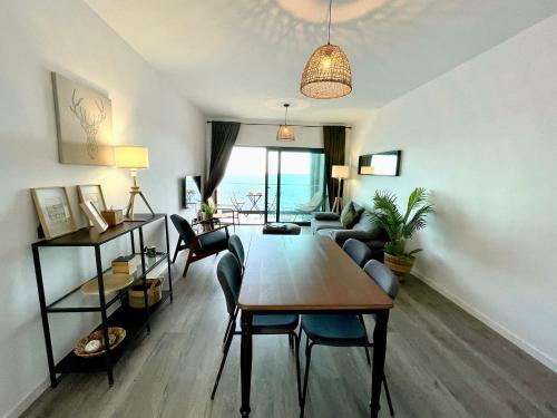 a living room with a table and chairs and a room with the ocean at Ocean Cliff Apartment in Santa Cruz