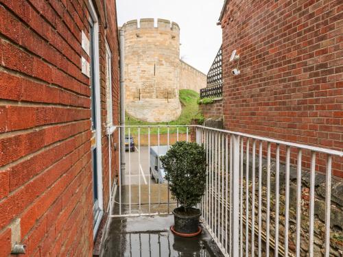 a brick building with a gate and a plant on a balcony at Grayz Studio in Lincoln