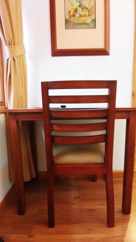 a wooden chair sitting in front of a desk at Hotel Boutique Casa Montalvo Cuenca in Cuenca