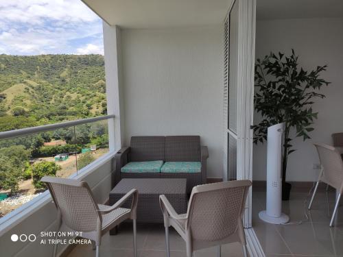 a balcony with a bench and a table and chairs at Apartasol Citadela Di Sole 1104 - Santafé de Antioquia in Santa Fe de Antioquia