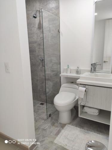 a bathroom with a shower and a toilet and a sink at Apartasol Citadela Di Sole 1104 - Santafé de Antioquia in Santa Fe de Antioquia