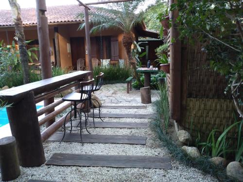 a garden with a table and chairs and a fence at Pousada da Terra Paraty in Paraty