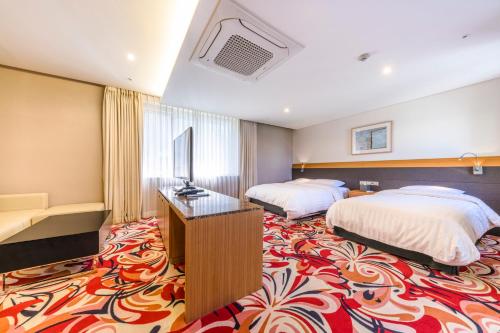 Postel nebo postele na pokoji v ubytování Shin Shin Hotel Jeju Airport