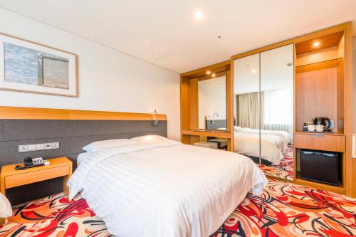 Postel nebo postele na pokoji v ubytování Shin Shin Hotel Jeju Airport