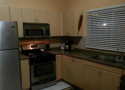 a kitchen with a refrigerator and a stove and a microwave at Luxurious Secret Escape in Portmore