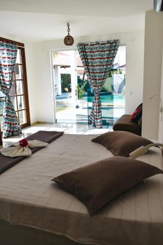 a bedroom with a large bed with a view of a pool at Pousada Kite Da Mary Cumbuco in Cumbuco