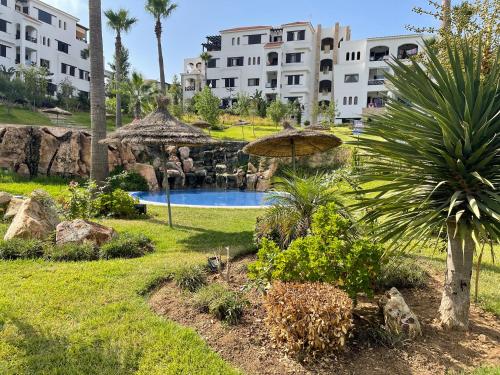 einen Garten mit Pool und Sonnenschirm in der Unterkunft Lilac Gardens Resort in Cabo Negro