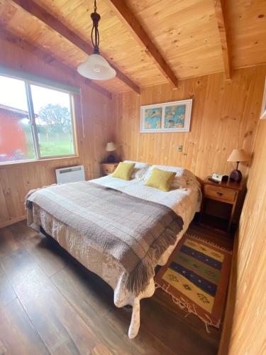 a bedroom with a bed in a wooden cabin at Cabañas Teresa Frutillar in Frutillar