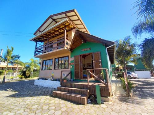 a small house with a green and yellow facade at Residencial Solar Del Nieto in Garopaba