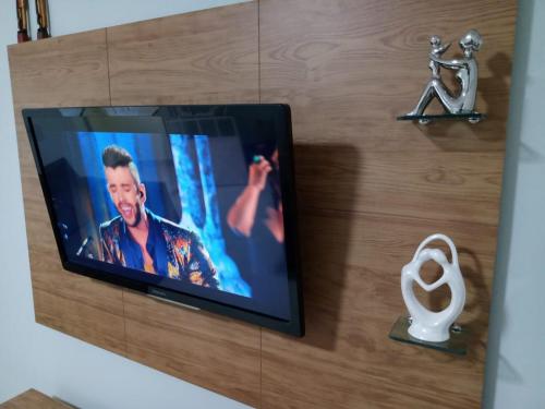 a television on a wall with a picture of a man at Casa Beira Rio Xingó in Canindé de São Francisco
