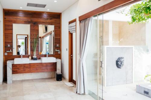 a bathroom with two sinks and a large mirror at Kamil Villas in Seminyak