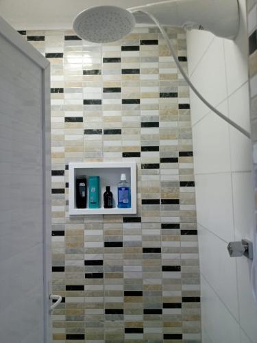 a bathroom with a shower with a tiled wall at Casa Beira Rio Xingó in Canindé de São Francisco