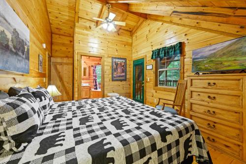 Schlafzimmer mit einem Bett und einem Deckenventilator in der Unterkunft GYPSY ROAD - Privacy! Log Cabin with Hot Tub, WiFi, DirecTV and Arcade in Sevierville