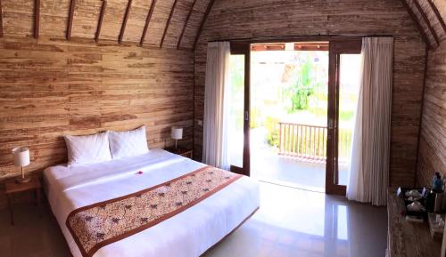 a bedroom with a bed and a large window at Maruti Beach Club in Toyapakeh