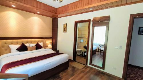 a bedroom with a large bed and a mirror at The Retreat Mashobra, Shimla in Shimla