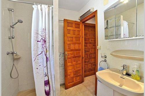 La salle de bains est pourvue d'un rideau de douche et d'un lavabo. dans l'établissement Villa Moraira Casa Toro 6 p avec piscine privée, à Teulada