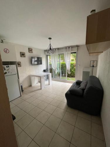 een woonkamer met een zwarte bank en een keuken bij Appartement 4 couchage Saint Lary Soulan in Saint-Lary-Soulan