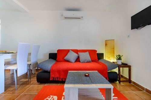 a living room with a red couch and a table at Apartments Dubrovnik Palm Tree Paradise in Dubrovnik
