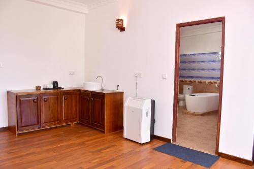 Habitación con baño con lavabo y nevera. en Hotel Nadee, en Aluthgama