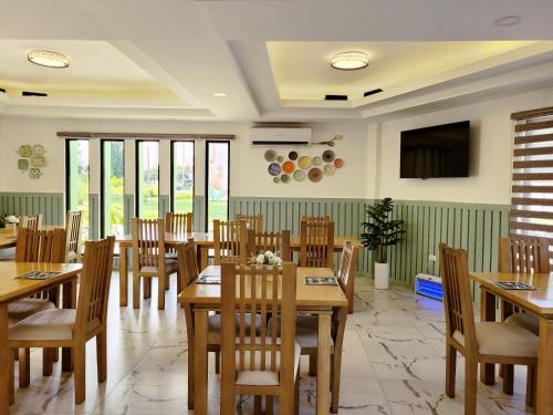 a restaurant with wooden tables and chairs and a flat screen tv at Casareal Hotel by Cocotel in Concepcion