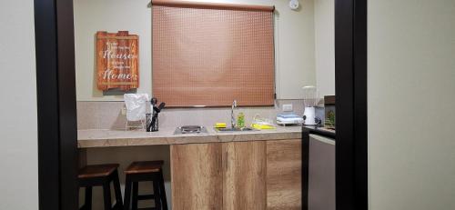 a kitchen with a sink and a window with stools at Habitación B independiente para parejas o ejecutivos in Manta