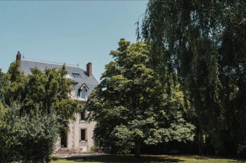 una gran casa blanca con árboles delante de ella en Maison Durieux en Limoges