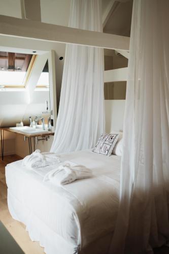 a white bed with a canopy in a bedroom at Maison Durieux in Limoges