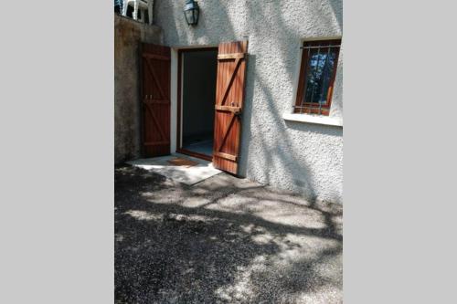 an open door of a house with a window at Studio en plein cœur de l'île de loisirs de Buthiers in Buthiers