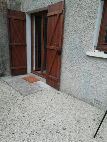 a pair of wooden doors on a building at Studio en plein cœur de l'île de loisirs de Buthiers in Buthiers