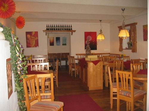 a restaurant with wooden tables and chairs and a dining room at Cobaneshof in Gobelsburg