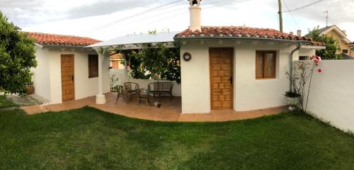 ein kleines weißes Haus mit einer Terrasse und Gras in der Unterkunft El Rincón de El Montán in Avilés