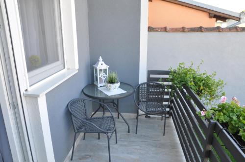 a small balcony with a table and chairs at Apartmani Ana Vukovar in Vukovar