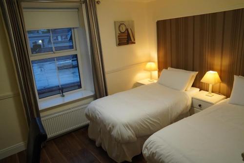 a hotel room with two beds and a window at The Fleet Inn in Killybegs