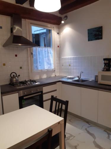 a kitchen with white cabinets and a table and a sink at Residenza Campo Ruga in Venice