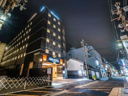 un bâtiment situé dans une rue de la ville la nuit dans l'établissement APA Hotel Kintetsu-Nara Ekimae, à Nara