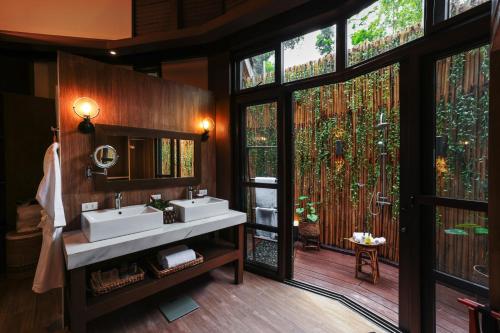 a bathroom with two sinks and a large window at LIHIM RESORTS in El Nido