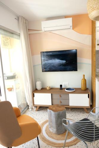 a living room with a tv on a wall at Elégant appartement moderne - Cure et vacances in Balaruc-les-Bains