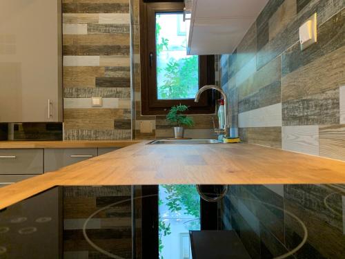 テッサロニキにあるAntony Luxury Suite in Thessalonikiのキッチン(木製のカウンタートップ、シンク付)