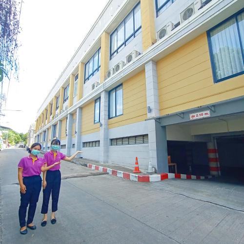two women standing in front of a building at Sriracha Orchid Hotel in Si Racha