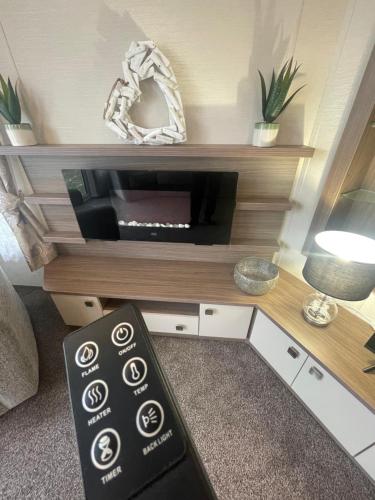 a living room with a tv on a shelf at Luxury Static Home 2 Bed Sleeps 6 in Great Yarmouth